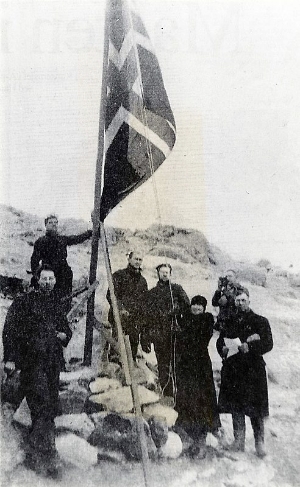 Caroline Mikkelsen raises the Norwegian flag at the cairn on Ingrid Christensen Land